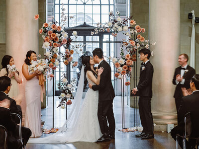 modern floral arch with toffee roses at museum wedding