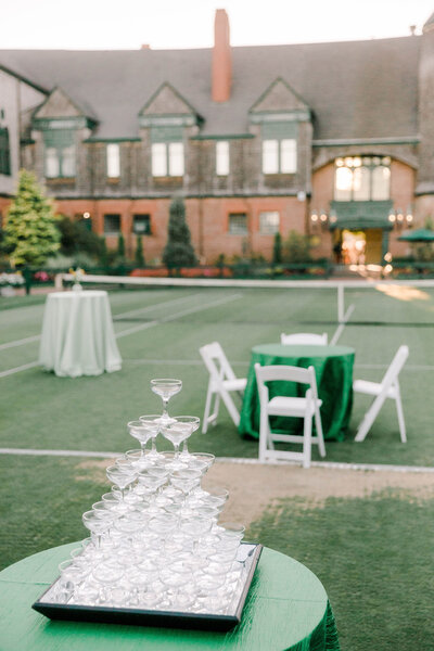outdoor wedding reception set up featuring stacked and filled champagne glasses