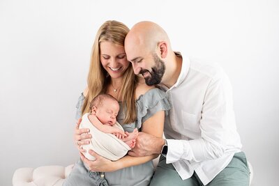 newborn held by parents