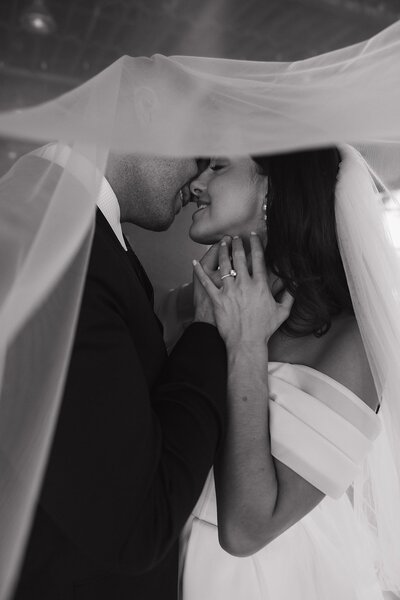 couple embracing under veil at wedding planned by wedding planner brooklyn ny