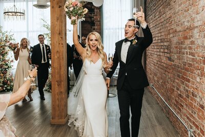 Couple walking down the aisle celebrating with Prosecco at Venue308 in Calgary