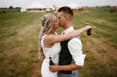 Bruidspaar kussen elkaar met bier in hand