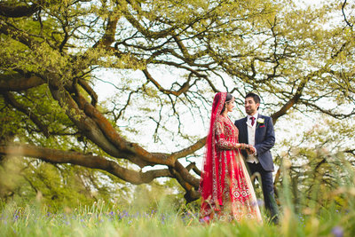 a stunning indian wedding photograph of a bride and groom hugging taken with flash