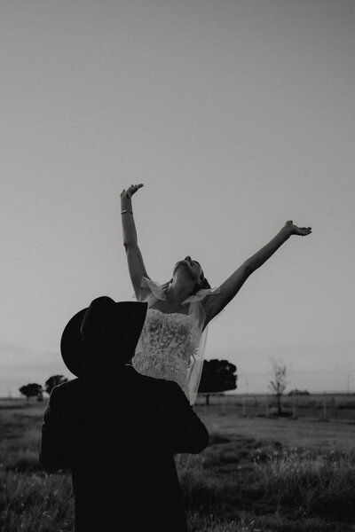groom lifting bride as her arms are up in the air taken by oklahoma wedding photographer