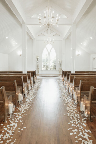 Wedding aisle with white petals and candles