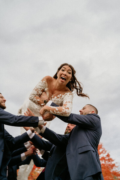 laughing bride being throw into air