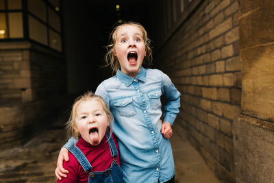 sisters pulling their crazy faces on a family shoot in saltaire