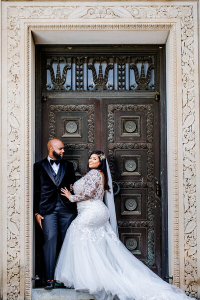 A luxury Black couple poses for wedding formals in Columbia, SC, at 1208 Washington Street and the South Carolina Statehouse. Featured in Munaluchi, with stunning design by Couture Events and makeup by Esthetized by Nadia.