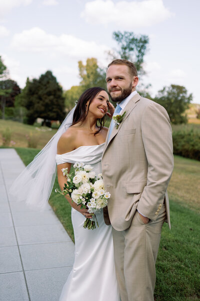 Bride gazing at groom during formal portraits at their coastal wedding