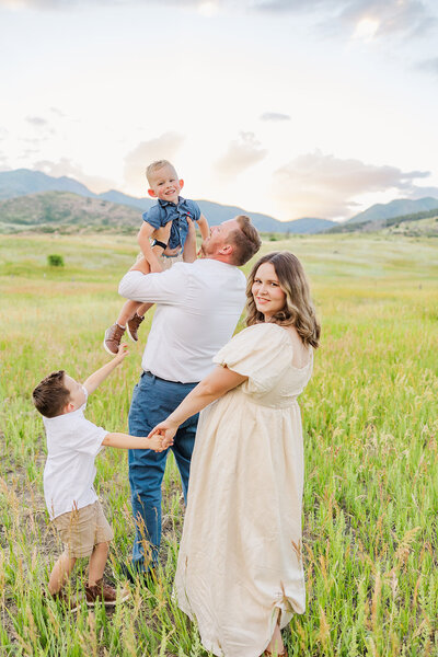Family of 4 laughing and having fun together during their family session in Utah.