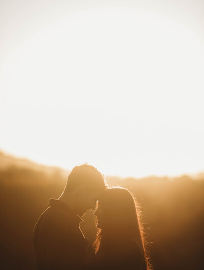 A couple embrace and touch foreheads at sunset captured by Blacksburg, Virginia photographer.