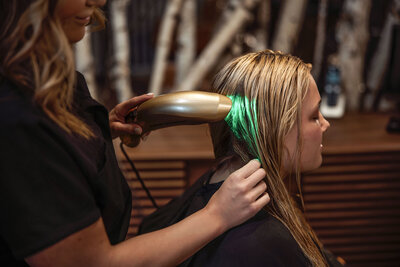 Client receiving an advanced red light facial treatment at Intrigue Salon, promoting relaxation and skin rejuvenation