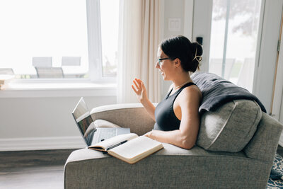 Man sitting in a chair at a table working from home at a laptop