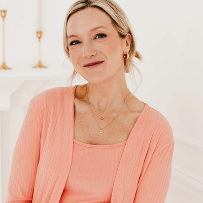 woman with blonde hair in pink dress and cardigan