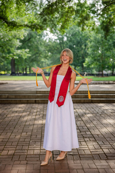 A University of South Carolina student taking her senior portraits on campus in front of the Thomas Cooper Library fountain