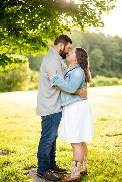 Bask in the beauty of an engagement photo at Southford Falls in Connecticut, where a couple finds themselves surrounded by the serenity of a picturesque field, celebrating their love