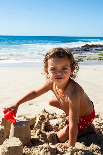 child building sandcastles on beach