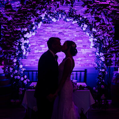 Bride and groom silhouette kissing under arch in ballroom | Wedding at 618 Restaurant | Freehold, New Jersey