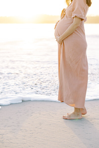 Maternity gown flowing in the wind during golden hour Fresno photoshoot