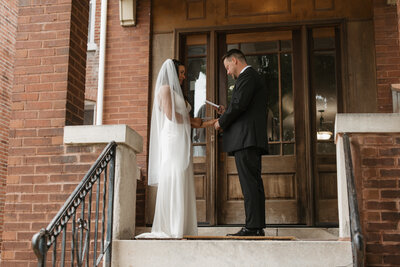 Bride and groom reading vows to each other before their Piper Palm House intimate wedding in St. Louis