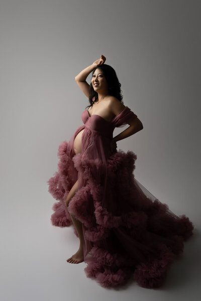 dark pink tulle maternity gown in warm lighting, perfect for showcasing red, pink, and purple dress options in the studio