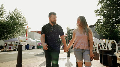 Couple walks along dock during engagement session