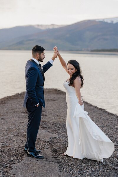 Bride and groom dance beside Colorado lake after eloping.