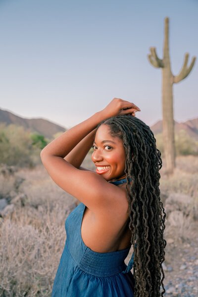 senior girl arms over head posing smiling at camera 