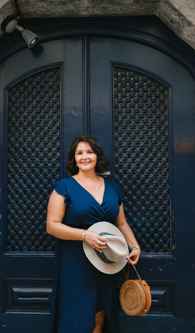 Maggie Dickens, LPCS, therapist at Cathartic Counseling, standing outdoors holding a hat, representing online anxiety therapy for women in Texas and Florida.