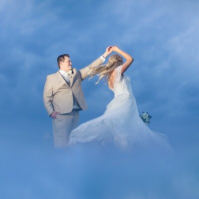 bride and groom dancing while surrounded by blue smoke