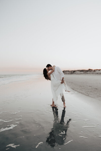 Couple sharing a kiss at CHarleston beach during engagement session