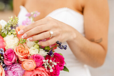 Bride touching her floral bouquet, taken by Minneapolis wedding photographer, Kacey Wyrick Photography