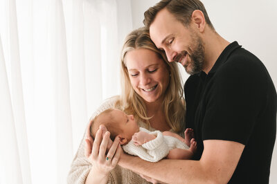 ouders die liefdevol naar hun pageboren baby kijken gefotografeerd door Digidroom In Malle, Antwerpen