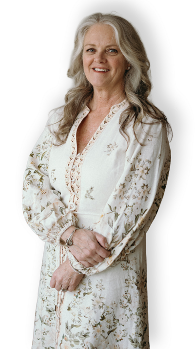 Janna Weldum of Eagle's Guiding Light looks welcomingly at the camera, standing in her wellness center, The Eyrie Eagle's Guiding Light.