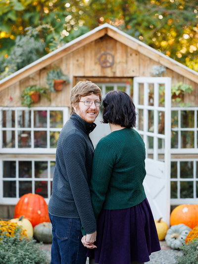 Beautiful portrait of a couple holding hands while the male smiles at the camera