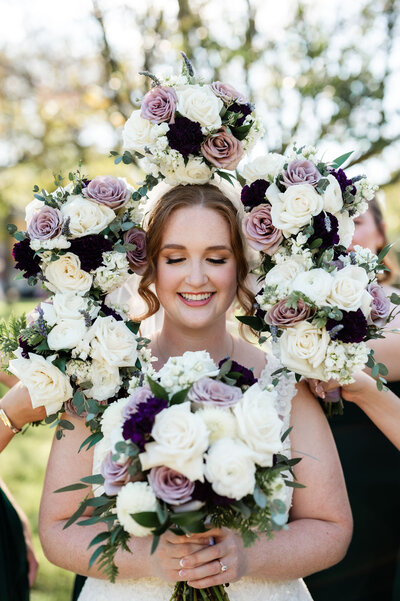 Pittsburgh bride holding her wedding bouquet while bridesmaids hold their bouquets around her face