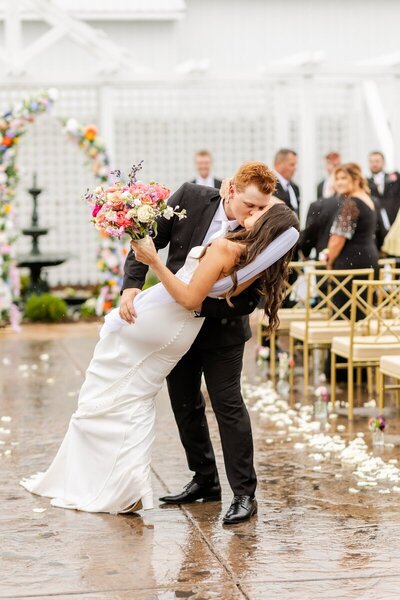 Bride and groom kissing and dipping in aisle, taken by wedding photographer minneapolis mn
