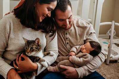 photo of parents with new baby and cat in nursery in Fort Collins Colorado