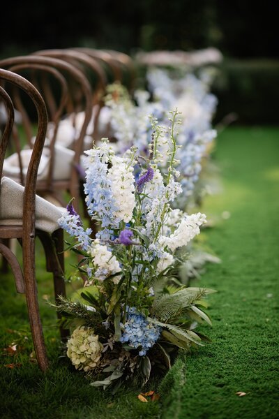 Close up detail shot of row of wedding chairs with a floral arrangement