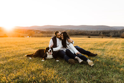 couple sitting in field smiling