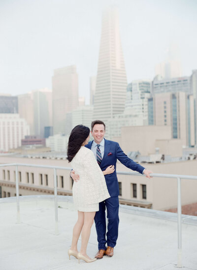 Rooftop engagement photography with an urban backdrop.