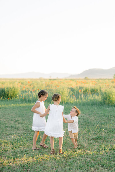 three children playing ring around the rosies