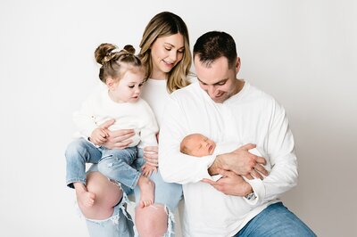 Expecting mom holds belly wearing a partially open white button down | Boho Maternity Photographher
