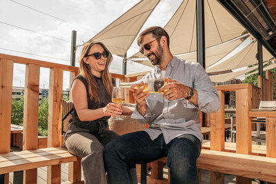 Asheville, North Carolina food photographer featuring two people sharing a glass of wine on the visuals rooftop at goldenhour.