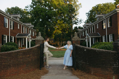 Man and Woman leaning against brick pillars and reaching out to each other in North Carolina, by Andrea-Marie Photography