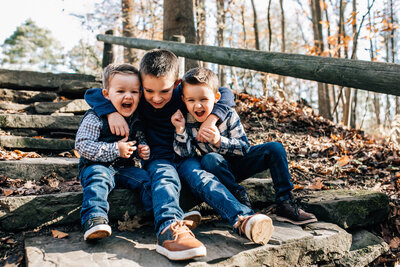 Family photography of three young boys playing outside.