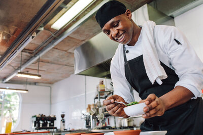 man in a kitchen preparing plates of food