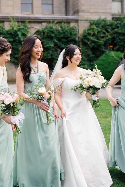 Wedding Photographer in Newport, RI, CT, and beyond | The Corteses | Bride with bridesmaid walking with the flowers.
