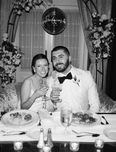 Couple in wedding attire standing forehead to forehead on NJ dock