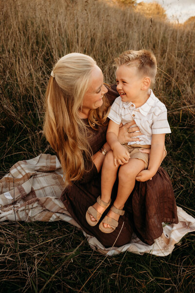 Lyla being held by her mother and sister during a newborn studio maternity photoshoot with michelle kelly photography